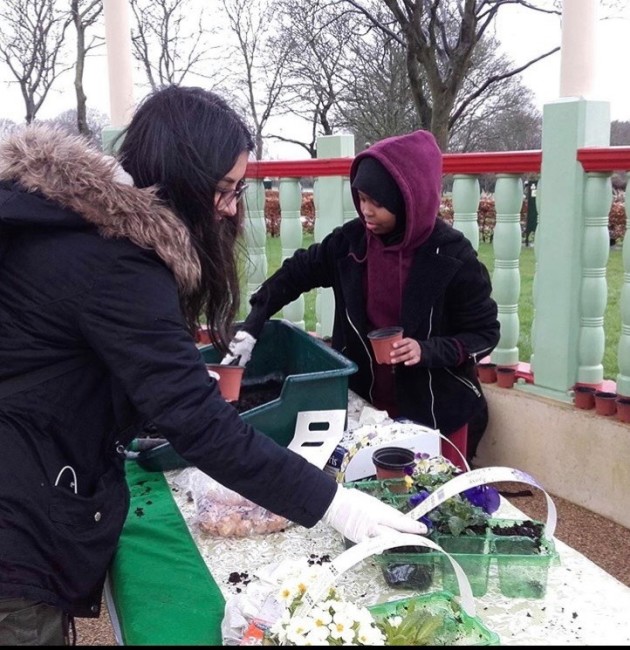 Young people potting plants in the park